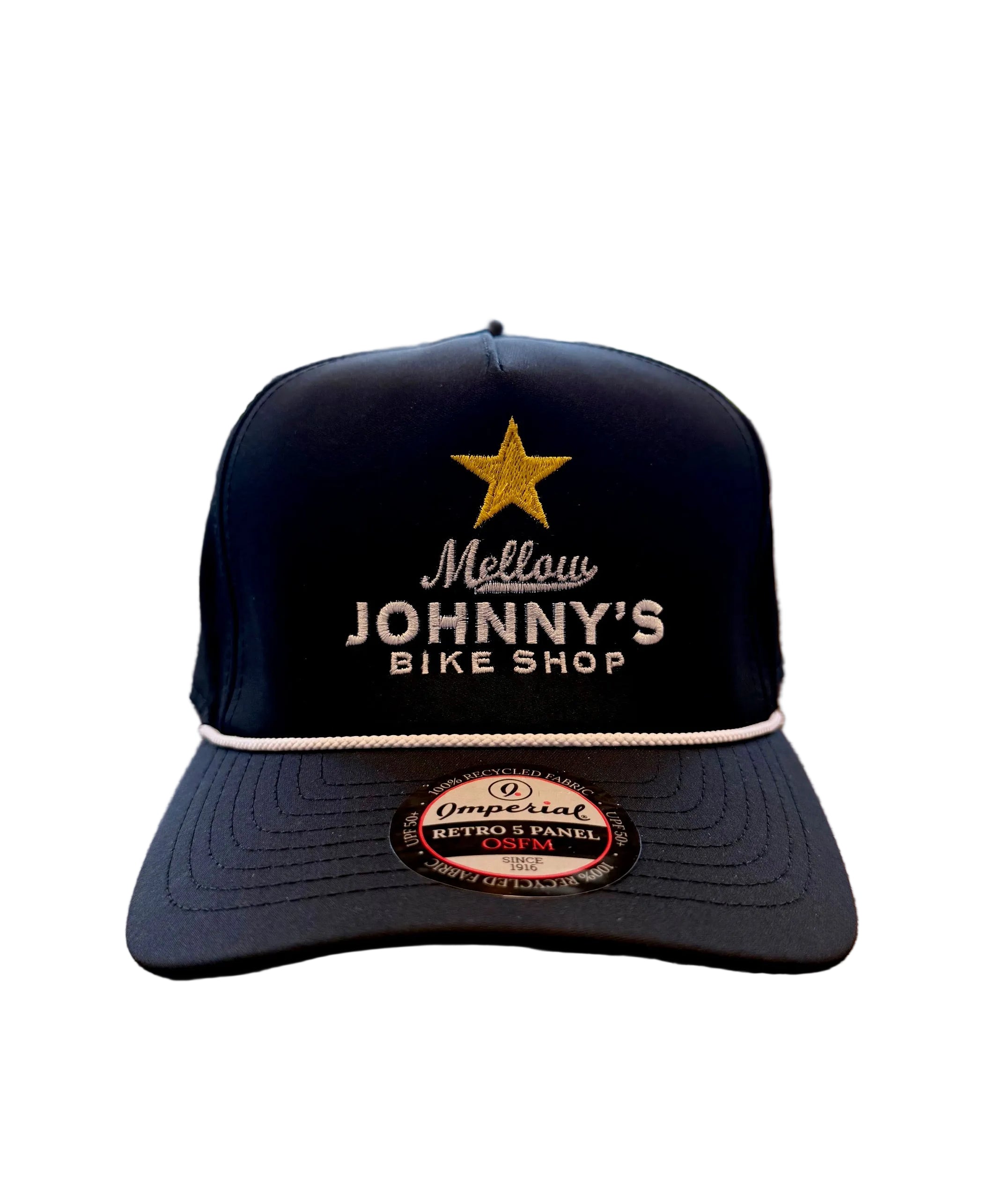 Black cap with 'Mellow Johnny's Bike Shop' logo on a wooden surface with bicycles in the background